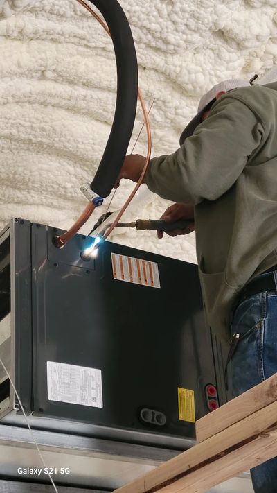 Technician brazing copper refrigerant lines